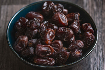 Mix of dates and nuts in plate on a white wood background .healthy food