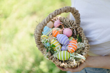 Easter egg hunt in spring garden. Funny teen girl with eggs basket and bunny ears on Easter egg...