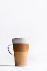 Latte macchiato in a tall glass on a white background. Cafe latte layered with milk in a high drinking glass. Minimalism. Сopy space
