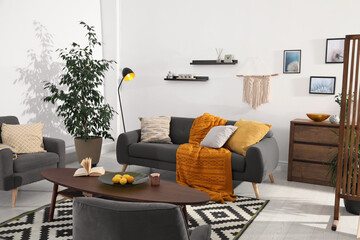 Stylish living room interior with comfortable sofa and wooden table