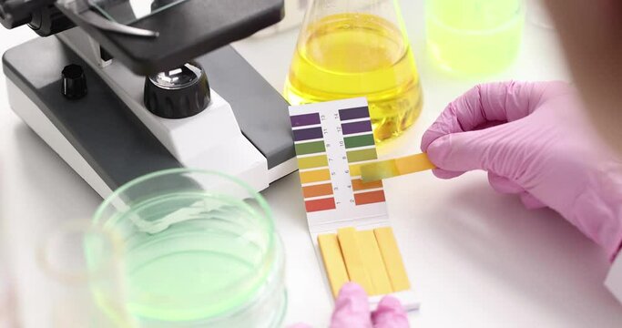 Chemist in lab checking with ph strips closeup