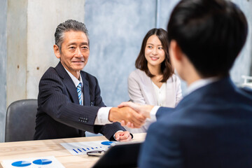 笑顔で握手をするビジネスパーソン