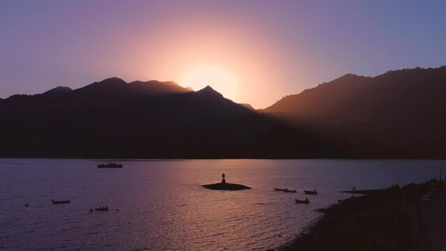 Warm sunset on calm coast with lighthouse and boats, Cocham&oacute; Valley Chile