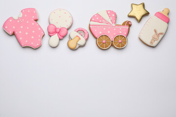 Cute tasty cookies of different shapes on white background, top view. Baby shower party