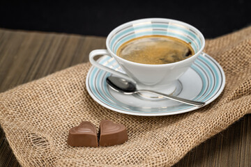 Coffee in a vintage porcelain cup and chocolate hearts for valentines day