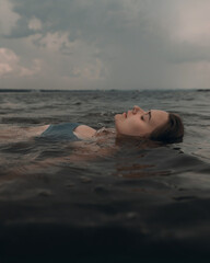 Girl swims relaxed in a beautiful mountain lake