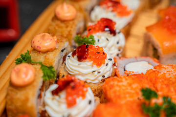 Close-up of rolls with red caviar on wooden substrate, japanese menu