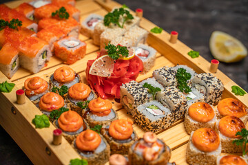 Close-up of japanese rolls with rice and red, black caviar on a wooden tray