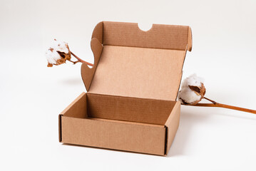 Brown cardboard box on white background with cotton flower