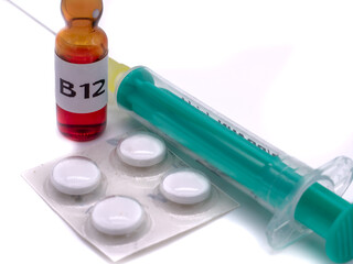 B12 Ampulle mit Spritze und Tabletten isoliert