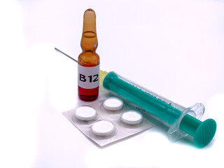 B12 Ampulle mit Spritze und Tabletten isoliert auf weißen Hintergrund