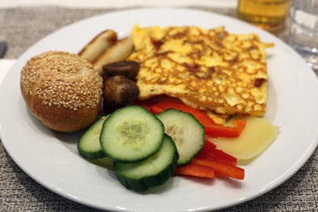 Delicious omelette with veggies, bread and sausages. Fresh and yummy hotel breakfast in Switzerland.