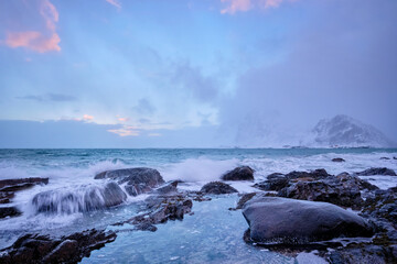 Coast of Norwegian sea on rocky coast in fjord on sunset