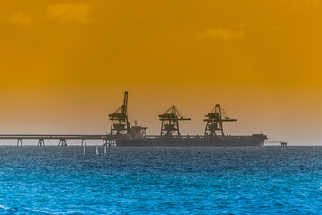 Gas container ship docked during sunset over the sea