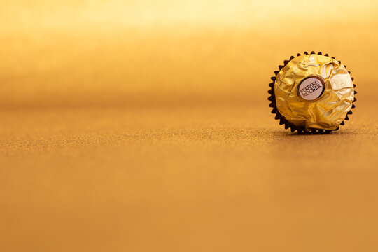isolated Ferrero Rocher premium chocolate on golden glitter background  Stock Photo | Adobe Stock