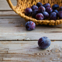 Plums on wooden background.