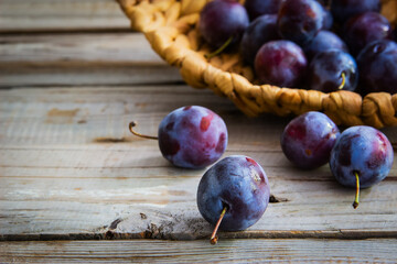 Plums on wooden background.