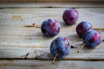 Plums on wooden background.