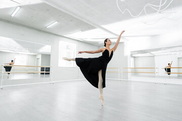 Fototapeta na wymiar full length view of ballerina dancing in studio during repetition