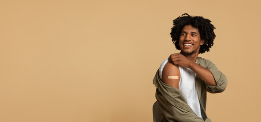 Covid-19 Vaccination. Vaccinated Black Guy Showing Arm With Plaster After Vaccine Injection