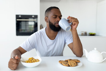 Black man suffering from insomnia drinking coffee