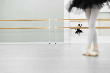 blurred girl dancing in ballet studio near reflection in mirror on background