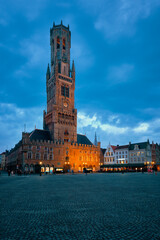 Naklejka premium Belfry tower famous tourist destination and Grote markt square in Bruges, Belgium on dusk in twilight