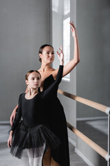 Fototapeta na wymiar preteen girl dancing with ballet master in studio
