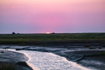 View of the last remnants of the setting sun over the Langwarder Groden/Germany on the North Sea 