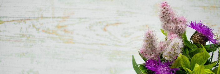 Banner with a bouquet of wild flowers on a wooden background. Rustic style. Copy space