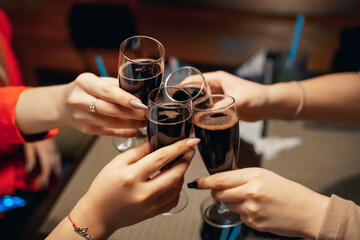 women's company celebrates the holiday, close-up of wine glasses together