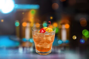 Fototapeta premium Glass of alcohol whiskey on the bar counter. Blurred interior of bar at the background.