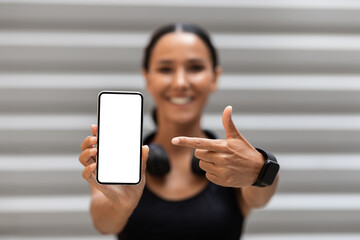 Fitness App. Sporty Fit Young Lady Pointing At Smartphone With White Screen