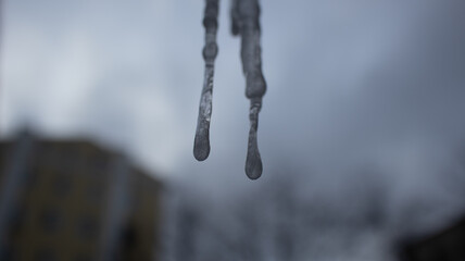 Icicle in the window against a cloudy background