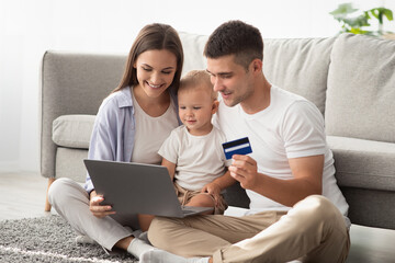 Parents And Little Baby With Laptop And Credit Card Making Online Shopping