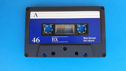 Retro audio cassette tapes on blue background. Vintage media device. Space to write on the label.