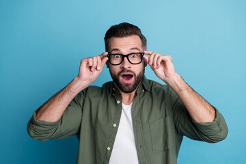 Photo of young shocked amazed guy open mouth see huge sale discount black friday isolated on blue...