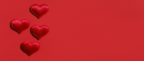 Valentine's day background. Red hearts on a red background. Flat lay. Web banner with copy space for design.