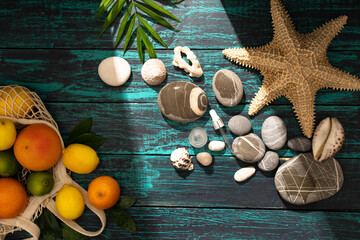 Beautiful summer holiday, fruits , orange, palm leaves on a shabby blue wooden background. The concept of summer and relaxation at sea, eco products ,holidays with family in a pleasant seaside resort.