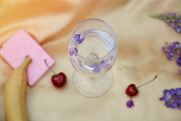 Glass with lupinus in the golden cloth at sunset. Wellness and natural concept. Adaptogenic ayuverdic drink concept. Conscious consumption.