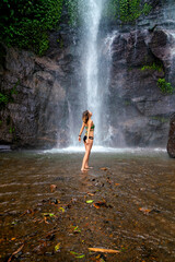 Fototapeta na wymiar Tourist woman near Munduk waterfall, Bali, Indonesia