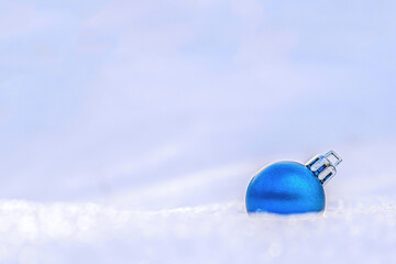 one blue christmas tree ball on white snow