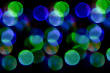 multicolored lights in soft focus on a black background bokeh
