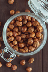 Close up brown hazel nut in glass jar and on wooden desk. Healthy organic vegetarian snack hazelnut