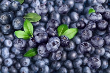 Demonstrating color of 2022 year very peri. Beautiful blueberries background with green leaf.