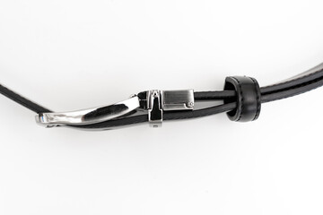 top view. part of black leather belt with an unbuttoned buckle on a white background.