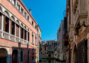 Fototapeta na wymiar Typical Venetian atmosphere, narrow canal and windows of the houses towards the water, Venezia ,Italy
