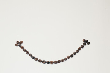 Background, frame of coffee beans, smiley laid out on a white background of coffee beans, copy space, isolated