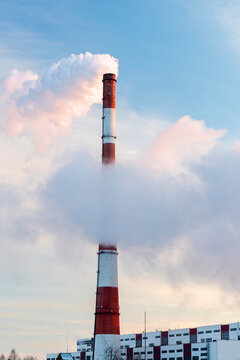 Smoke stack with smoke emission. Plant pipes pollute atmosphere. Industrial factory pollution. Vertical photo