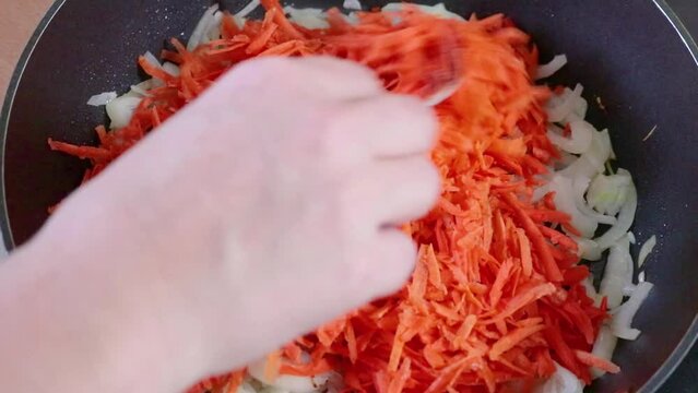 Roasting carrots and onions in a pan. Cooking food. Timelapse, 60fps.